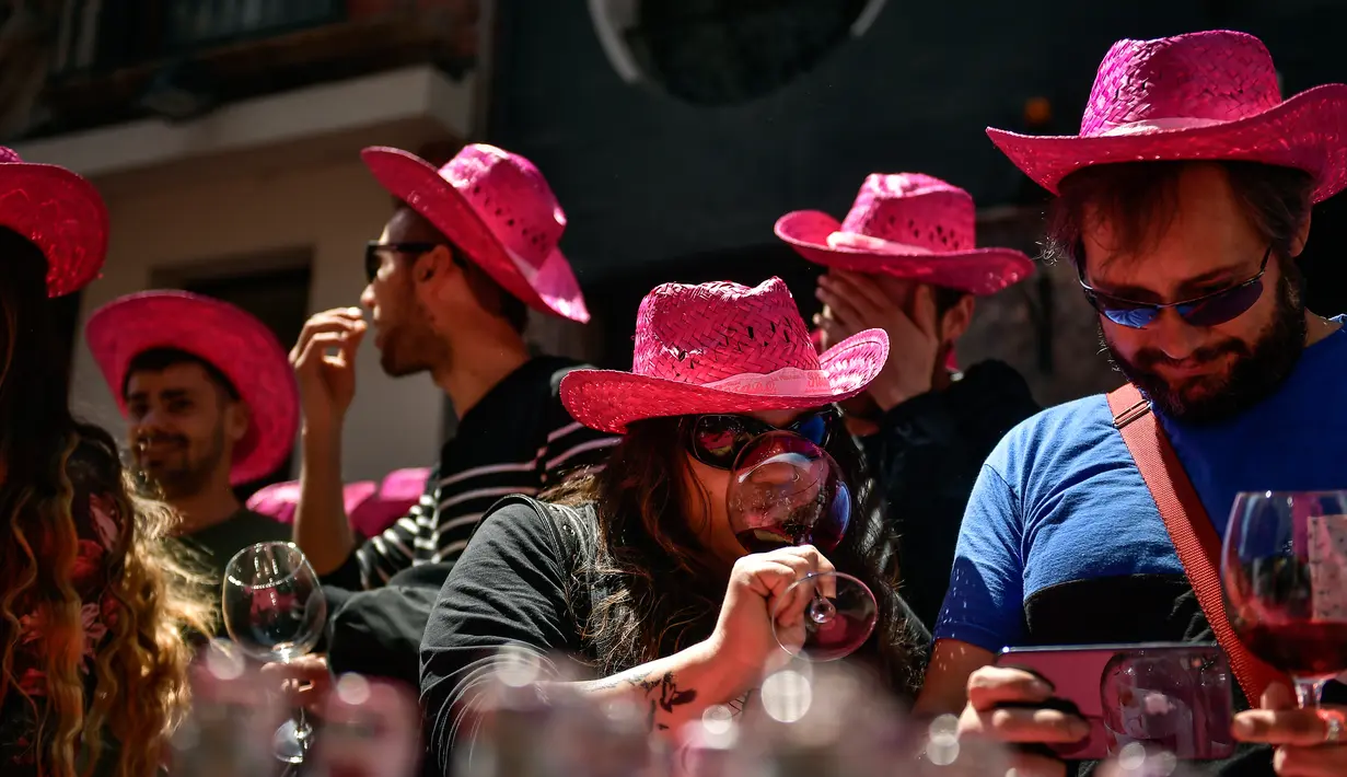 Pengunjung mencicipi anggur mawar Spanyol untuk mempromosikan minuman tersebut di Pamplona, Spanyol, Sabtu (19/5). (AP Photo/Alvaro Barrientos)