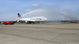 Sebuah pesawat Lufthansa bertuliskan 'Siegerflieger Fanhansa' yang membawa Timnas Jerman mendapat sambutan guyuran air saat mendarat di Bandara Tegel, Berlin, (15/7/2014). (REUTERS/Karina Hessland/Pool)
