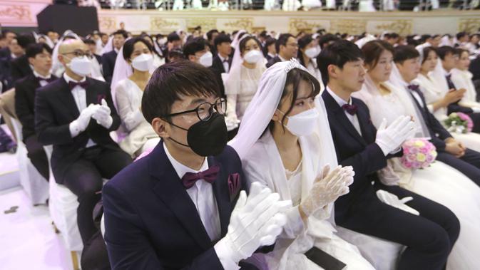 Sejumlah pasangan berdoa saat mengikuti upacara pernikahan massal di Cheong Shim Peace World Center, Gapyeong, Korea Selatan, Jumat, (7/2/2020). Wabah virus corona yang melanda sejumlah wilayah di dunia tidak menghalangi antusias warga Korsel mengikuti acara itu. (AP Photo/Ahn Young-joon)