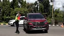 <p>Polisi mengarahkan kendaraan saat melakukan sistem buka tutup jalan menuju Pelabuhan Merak, Cilegon, Banten, Jumat (29/4/2022). Sistem buka tutup tersebut membuat kemacetan panjang hingga ke dalam Tol Tangerang-Merak. (Liputan6.com/Angga Yuniar)</p>