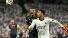 Gelandang Real Madrid, Jude Bellingham, berduel dengan bek Man City, Manuel Akanji, dalam laga leg pertama perempat final Liga Champions di Santiago Bernabeu, Rabu (10/4/2024) dini hari WIB. Real Madrid dan Man City bermain imbang 3-3. (JAVIER SORIANO / AFP)