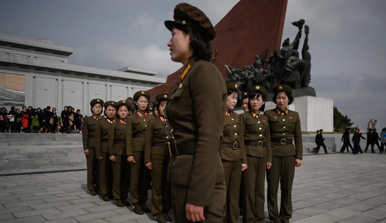 Tentara wanita Korea Utara berkumpul setelah memberi penghormatan kepada patung-patung pemimpin Korea Utara Kim Il Sung dan Kim Jong Il di Pyongyang (15/4). Hari ulang tahun Kim Il Sung merupakan salah satu hari libur di Korea Utara. (AFP Photo/Ed Jones)