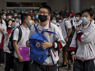 Siswa yang mengenakan masker bersiap memasuki sekolah untuk hari pertama ujian masuk perguruan tinggi nasional China, atau dikenal gaokao, di Beijing, Selasa (7/6/2022). Lebih dari 11 juta siswa sekolah menengah di seluruh China akan mengikuti ujian masuk perguruan tinggi tahunan setelah negara itu baru saja mengatasi wabah COVID-19 yang parah di Shanghai dan Beijing (AP Photo/Andy Wong)