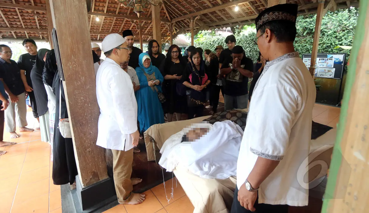 Sejumlah pelayat tampak berdoa di depan jenazah Didi Petet di musala di rumah kediaman almarhum di kawasan Ciputat, Tangsel, Jumat (15/5/2015). Didi Petet meninggal di usia 58 tahun karena diduga menderita asam lambung. (Liputan6.com/Helmi Afandi)