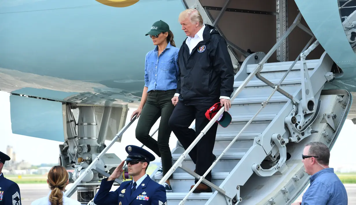 Presiden AS Donald Trump dan Ibu Negara Melania Trump tiba di Lapangan Ellington di Houston (2/9). Melania tampil kasual dengan mengenakan kemeja jeans dan sepatu sneakers. (AFP Photo/Nicholas Kamm)
