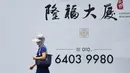 Seorang wanita mengenakan topi dan penutup wajah untuk menghadapi teriknya panas matahari di sebuah jalanan di Beijing, Rabu (12/7).Sebanyak 21 provinsi di China diterpa gelombang panas dengan suhu maksimum mencapai 50 derajat Celsius. (WANG ZHAO/AFP)