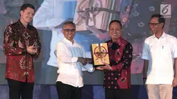 Ketua Dewan Komisioner OJK Wimboh Santoso memberikan bingkisan kepada Menteri Riset, Teknologi, dan Pendidikan Tinggi (Menristekdikti) Mohamad Nasir (kedua kanan) dalam acara Aksi Mahasiswa dan Pemuda Indonesia Menabung (AKSiMUDA) 2019 di Jakarta, Selasa (30/7/2019). (merdeka.com/Iqbal S Nugroho)