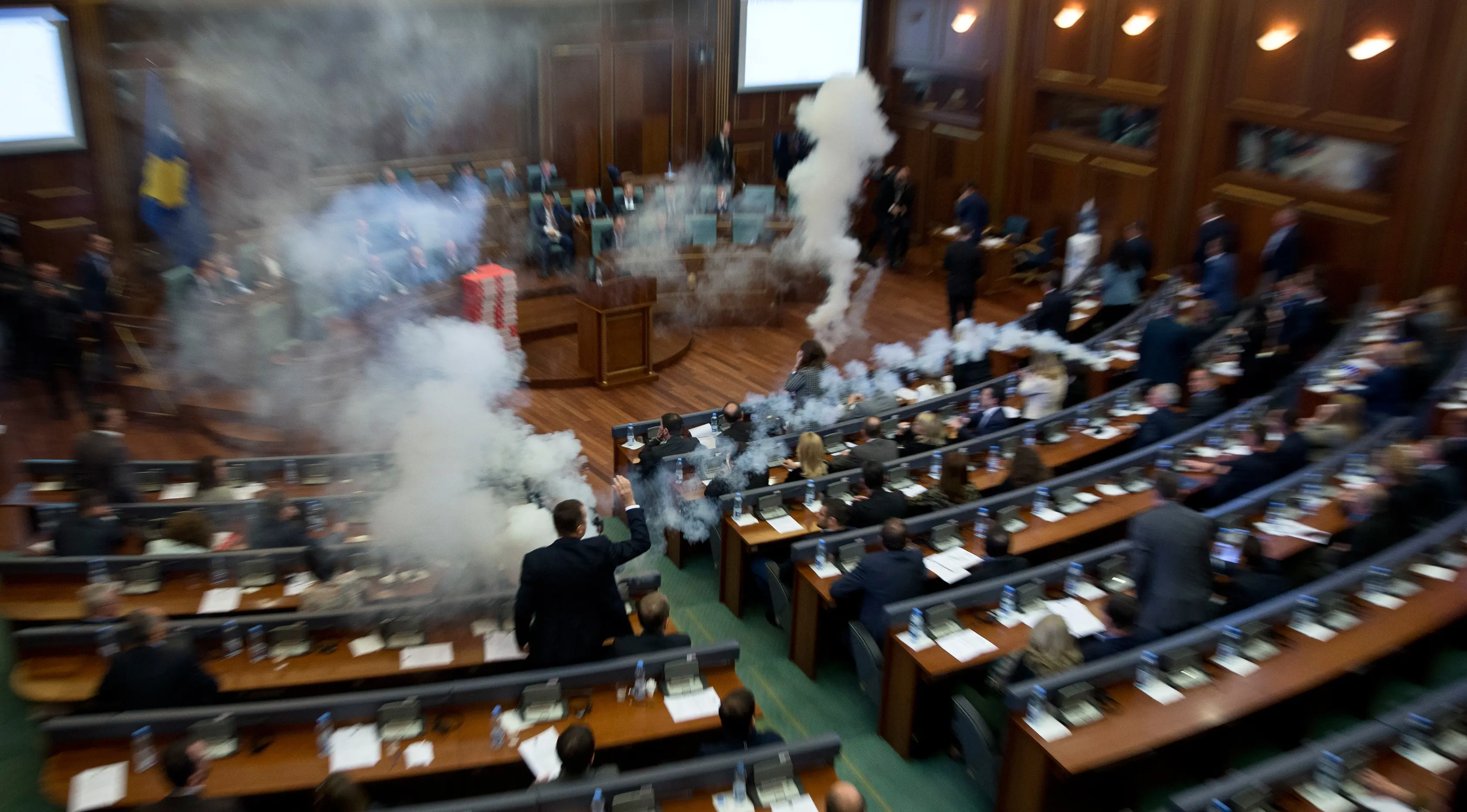 Sebuah gas air mata meledak dalam rapat parlemen di ibu kota Kosovo, Pristina, Rabu (21/3). Aksi anggota Partai Vatevendosje itu dilakukan demi mencegah pemungutan suara terkait masalah kesepatakan perbatasan dengan Montenegro. (AP Photo/Visar Kryeziu)