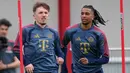 Mereka membutuhkan kemenangan dengan selisih minimal dua gol untuk lolos langsung ke final di Budapest. Tampak dalam foto, pemain Bayern Munchen, Lebbart Karl (kiri) dan Michael Olise saat sesi latihan jelang pertandingan leg kedua semifinal Liga Champions 2025/2026 melawan Paris Saint-Germain (PSG) di Jerman, Selasa 5 Mei 2026. (AP Photo/Matthias Schrader)
