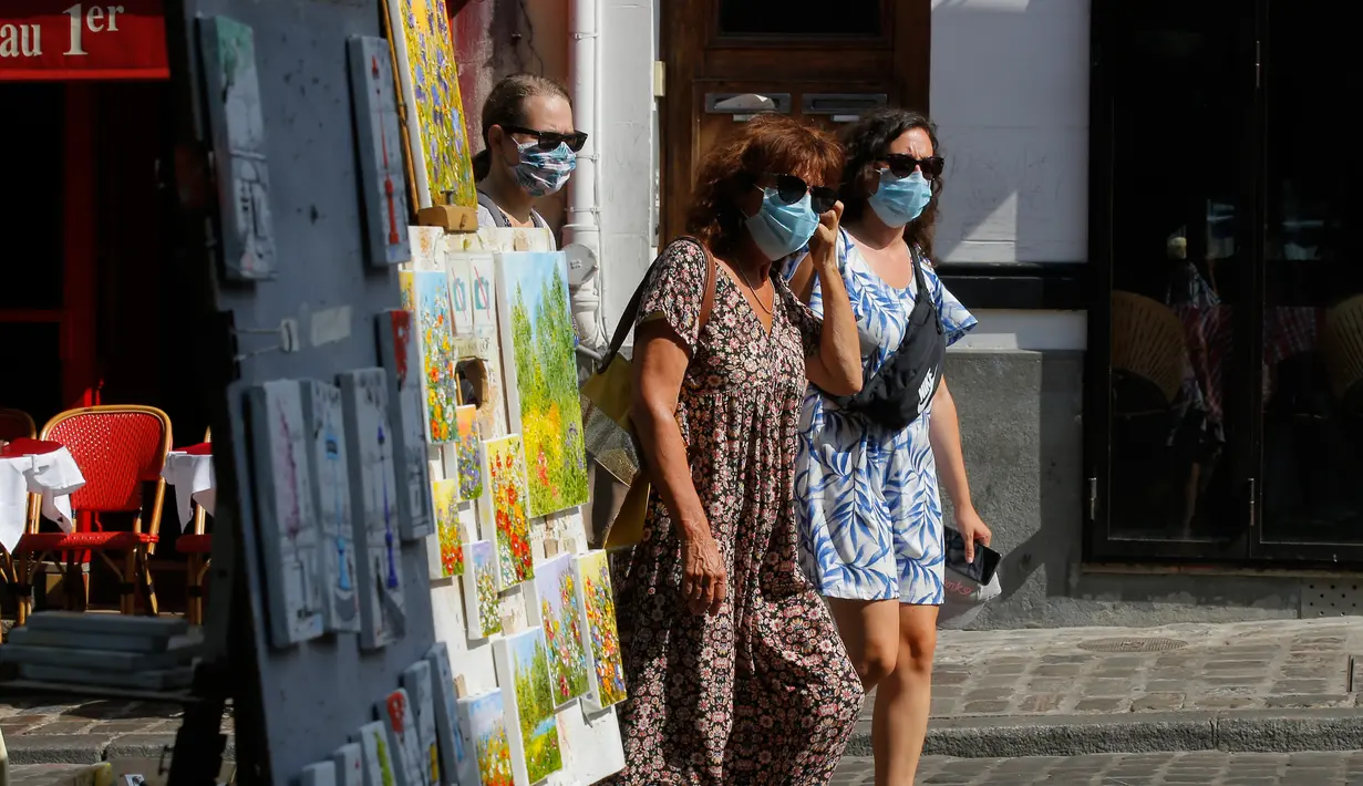 Turis berjalan-jalan di distrik Montmartre, Paris pada Senin (10/8/2020). Pemerintah Kota Paris mengumumkan masker wajib dipakai di area luar ruangan yang ramai di ibu kota Prancis itu mulai Senin (10/8) untuk mengendalikan peningkatan tingkat infeksi virus corona. (AP Photo/Michel Euler)