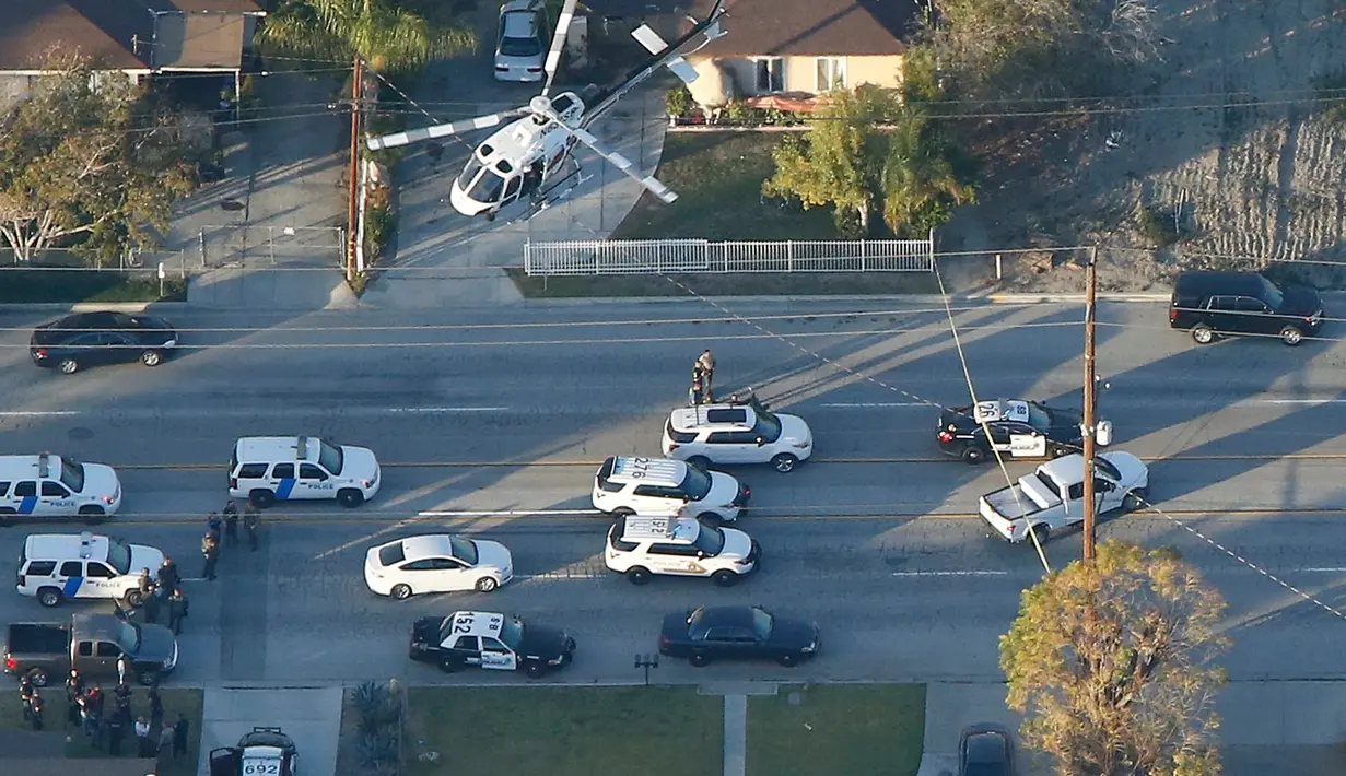 Helikopter diterjunkan mencari kendaraan tersangka penembakan di pusat layanan bagi kaum difabel Inland Regional Center, California, Rabu (2/12). 14 orang tewas dan 17 lainnya terluka akibat penembakan yang dilakukan tiga orang (REUTERS/Mario Anzuoni)