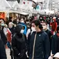 Pengunjung memakai masker untuk mencegah penyebaran COVID-19 saat berjalan di pasar malam di Paris, Prancis, 29 Desember 2021. (AP Photo/Thibault Camus)