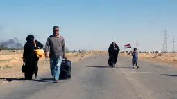 Sejumlah Warga  melarikan diri dari rumah mereka karena bentrokan antara pasukan keamanan Irak dengan militas ISIS di kota Hit, provinsi Anbar, (5/4/2016). (REUTERS/Stringer)