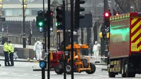 Petugas forensik meneliti lokasi serangan teror Inggris di dekat gedung parlemen di London, Rabu (22/3). Sedikitnya lima orang tewas dalam serangan teror di Jembatan Westminster dan di dekat Gedung Parlemen itu. (Jonathan Brady/PA via AP)