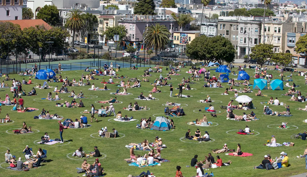 Orang-orang bersantai sembari duduk berjauhan di sejumlah area yang diberi tanda lingkaran guna memastikan dilakukannya jaga jarak sosial (social distancing) di tengah pandemi COVID-19 di sebuah taman di San Francisco, Amerika Serikat (AS), pada 24 Mei 2020. (Xinhua/Li Jianguo)