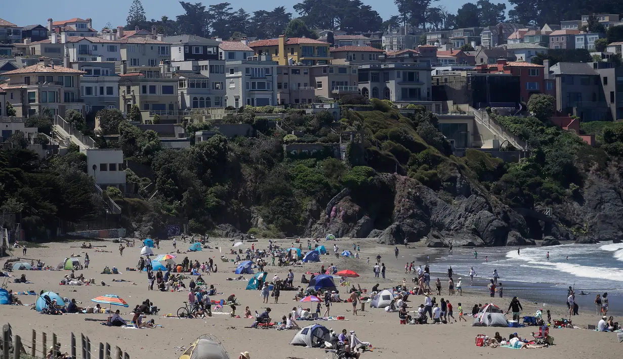 Orang-orang mengunjungi Pantai Baker selama masa pandemi covid-19 di San Francisco pada Minggu (24/5/2020). Warga Amerika Serikat mengabaikan pedoman jarak sosial dan memilih berjemur di pantai ketika angka kematian akibat virus corona di negara itu mendekati 100.000 orang. (AP/Jeff Chiu)
