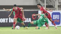 Pemain Timnas Indonesia U-23, Ilham Rio Fahmi (kiri) berusaha melewati adangan dua pemain Turkmenistan pada laga Kualifikasi Piala Asia U-23 2024 di Stadion Manahan, Solo, Selasa (12/09/2023). Timnas Indonesia berhasil melaju ke putaran final Piala Asia U-23 2024 setelah menang dengan skor 2-0 atas Turkmenistan. (Bola.com/Arief Bagus)