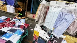 Pedagang menata masker berbahan kain di Pasar Pagi, Jakarta, Senin (6/4/2020). Meningkatnya permintaan akan masker kain ini juga dimanfaatkan oleh penjahit pakaian yang beralih untuk memproduksi dan menjual masker kain. (Liputan6.com/Fery Pradolo)