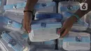 Mahasiswa menyiapkan makanan gratis untuk masyarakat di UKI, Cawang, Jakarta, Selasa (16/3/2021). Kegiatan ini memberikan 500 bungkus nasi, masker dan vitamin setiap harinya sejak pukul 06.00 WIB, untuk meringankan beban masyarakat di masa pandemi Covid-19. (Liputan6.com/Herman Zakharia)