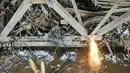 Petugas mengelas besi pondasi jembatan Rawajati untuk mempermudah pembongkaran, Jakarta, Selasa (15/3). Gubernur DKI Basuki Tjahaja Purnama meminta Dinas PU segera membongkar Jembatan tersebut karena menjadi penyebab banjir. (Liputan6.com/Yoppy Renato)