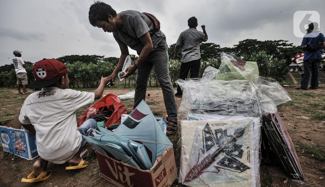 Seorang anak saat membeli layang-layangdi pinggir Kanal Banjir Timur (KBT), Duren Sawit, Jakarta, Senin (19/4/2021). KBT menjadi lokasi favorit warga untuk mengisi waktu menunggu buka puasa atau ngabuburit, salah satunya dengan bermain layang-layang bersama keluarga. (merdeka.com/Iqbal S Nugroho)