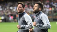 Lionel Messi (kiri) dan Jordi Alba (kanan) saat melakukan pemanasan menjelang laga uji coba Inter Miami kontra Hong Kong XI, Minggu (4/2/2024). (Peter PARKS / AFP)