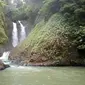 Dihimpit dua tebing tinggi yang lebat tumbuhan sekitarnya, dua air terjun dengan sempurna meluncur deras di celah kedua tebing itu, membuat siapapun yang datang ke Curug Cikolengka, Tasikmalaya takjub. (Liputan6.com/Jayadi Supriadin)