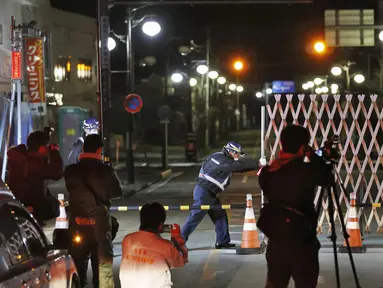 Petugas membuka gerbang ke kota Futaba, prefektur Fukushima, Jepang utara, Rabu (4/3/2020). Pembukaan masuk sebagian kota ini merupakan upaya pemerintah Jepang untuk memulihkan kepercayaan masyarakat, dan kesiapan mereka dalam menggelar Olimpiade Tokyo pada Agustus mendatang. (Kyodo News via AP)