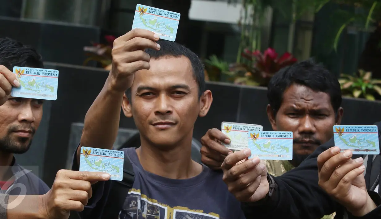 Aktivis Koalisi Masyarakat Sipil menunjukan KTP Elektronik saat melakukan aksi di depan Gedung KPK, Jakarta, Minggu (12/3). Aksi ini bertujuan untuk menuntut agar KPK mengusut tuntas kasus mega korupsi KTP Elektronik. (Liputan6.com/Immanuel Antonius)