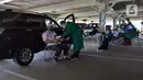 Petugas medis memeriksa kondisi lansia saat vaksinasi COV-19 secara drive thru di RSUI, Depok, Jawa Barat, Kamis (25/3/2021). XL Axiata bekerja sama dengan RSUI yang didukung Kemenkes dan Pemkot Depok menggelar program Sentra Vaksinasi Indonesia Bangkit untuk lansia. (Liputan6.com/Herman Zakharia)