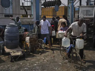 Warga Palestina mengumpulkan air minum di pabrik desalinasi di Deir al-Balah, Jalur Gaza Tengah, Rabu 13 Agustus 2025. (AP Photo/Abdel Kareem Hana)