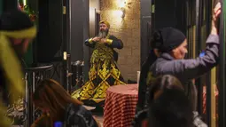 Usai berbuka puasa di bulan suci Ramadan, salah satu restoran di Damaskus, Suriah, menggelar pertunjukan yang lain dari biasanya, yakni tarian sufi. Tampak dalam foto, seorang penari bersiap di belakang panggung sebelum para darwis berputar menampilkan tarian Sufi di sebuah restoran selama pertunjukan yang diadakan setelah berbuka puasa selama bulan suci Ramadan 1447 Hijriah, di distrik bersejarah Damaskus, Suriah, Minggu 22 Februari 2026. (AP Photo/Ghaith Alsayed)