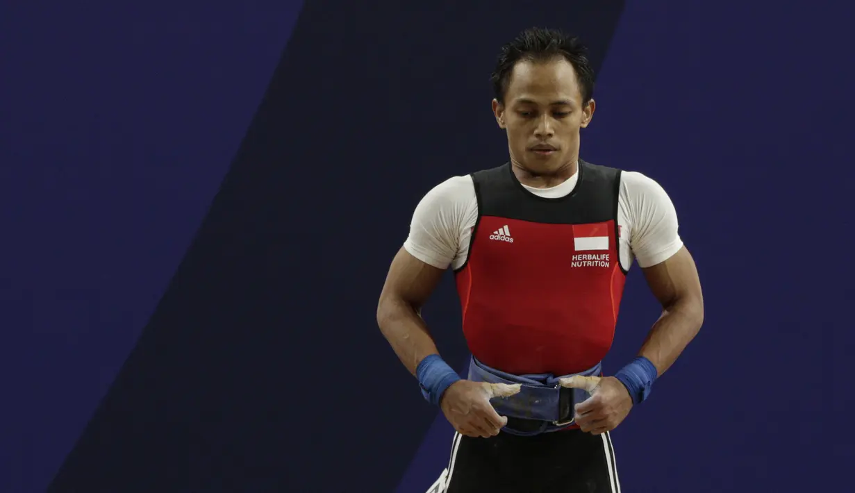 Lifter Suratman bersiap melakukan angkatan saat SEA Games 2019 cabang angkat besi nomor 55 kg di Stadion Rizal Memorial, Manila, Minggu (1/12). Dirinya meraih perak dengan total angkatan 250 kg. (Bola.com/M Iqbal Ichsan)