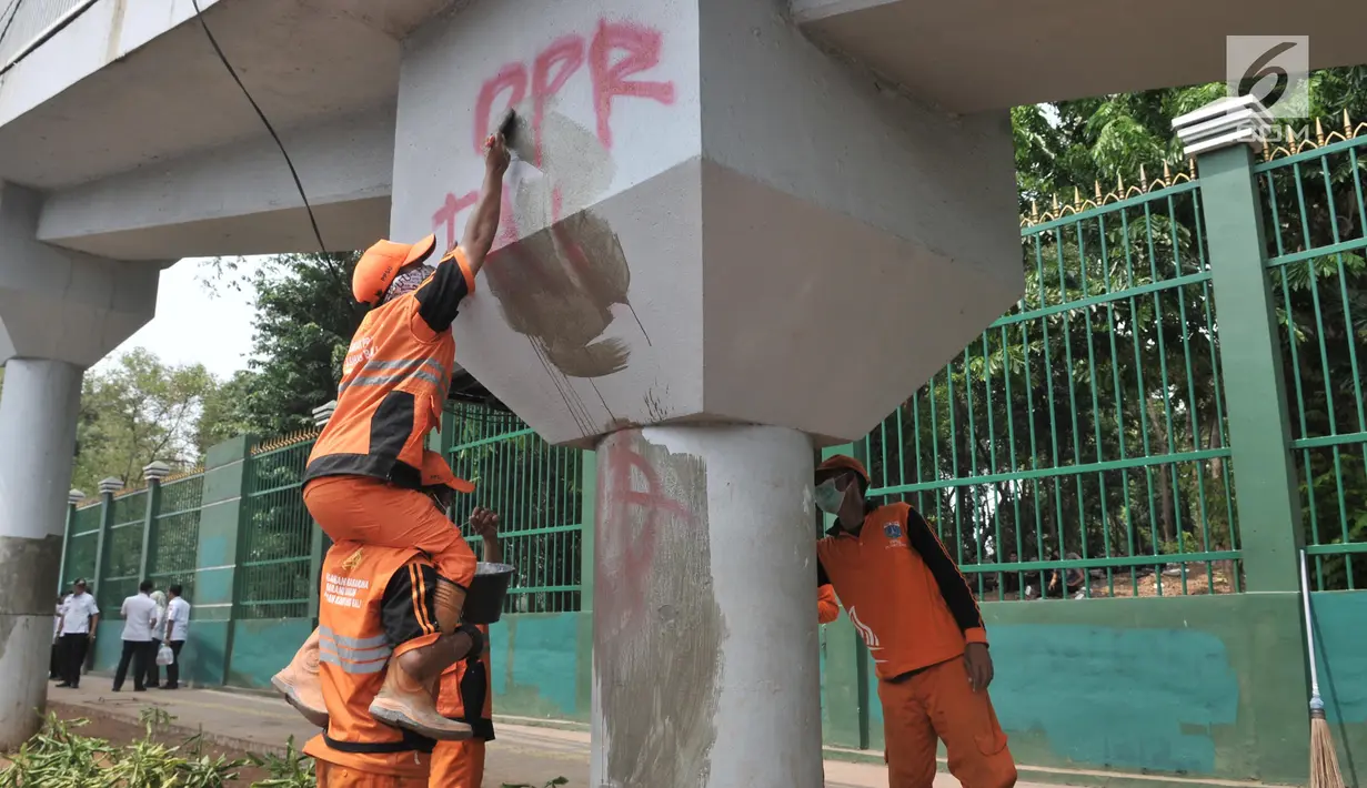 Petugas PPSU membersihkan coretan yang mengotori tembok di kawasan Gedung DPR, Jakarta, Rabu (25/9/2019). Demonstrasi mahasiswa yang berujung ricuh yang berujung kerusuhan tersebut menyebabkan fasilitas umum rusak dan penuh coretan yang dibuat oleh pendemo. (merdeka.com/Iqbal S Nugroho)