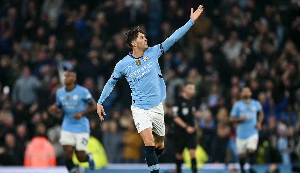 Pemain Manchester City, John Stones, melakukan selebrasi setelah mencetak gol ke gawang Arsenal pada laga Liga Inggris di Stadion Etihad, Minggu (22/09/2024). (AP Photo/Dave Thompson)