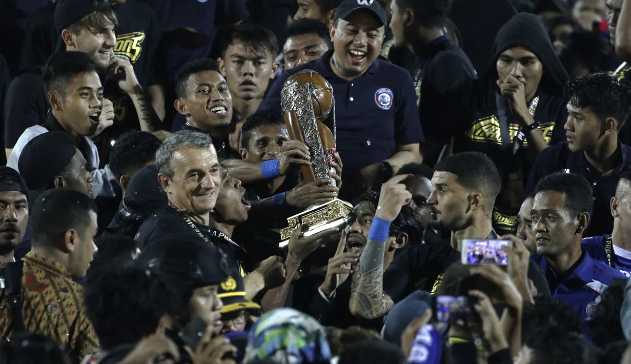 Pelatih Arema FC, Milomir Seslija, bersama pemain merayakan gelar juara Piala Presiden 2019 usai menaklukkan Persebaya Surabaya di Stadion Kanjuruhan, Jumat (13/4). Arema FC menang 2-0 atas Persebaya. (Bola.com/Yoppy Renato)