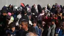 PBB juga melaporkan bahwa lebih dari 100 permintaan misi bantuan ke Gaza telah ditolak oleh Israel sejak gencatan senjata dimulai. Tampak dalam foto, warga Palestina yang terlantar, anak-anak, dan dewasa, menunggu makanan di sebuah tempat penampungan yang telah dihuni keluarga-keluarga di Nuseirat, pusat Jalur Gaza, pada 23 November 2025. (EYAD BABA/AFP)