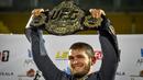 <p>Foto pada 8 Oktober 2018, juara kelas ringan UFC Khabib Nurmagomedov dari Rusia mengangkat sabuk juara setibanya di Makhachkala. Khabib Nurmagomedov mengumumkan pensiun dari dunia seni bela diri campuran (MMA) seusai mengalahkan Justin Gaethje dalam UFC 254, Minggu (25/10/2020). (Vasily MAXIMOV/AFP)</p>
