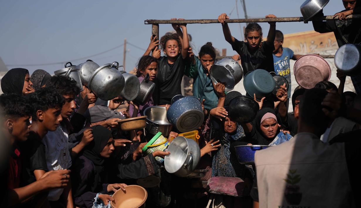 Warga Palestina menunggu bantuan gula dan beras di dapur umum di Khan Younis, Jalur Gaza selatan, Jumat, 31 Oktober 2025. Di tengah berlangsungnya kesepakatan gencatan senjata antara Israel dan Hamas, warga Palestina di Khan Younis, Jalur Gaza selatan, masih menghadapi kesulitan dalam mendapatkan bantuan pangan, termasuk gula dan beras. (AP Photo/Abdel Kareem Hana)