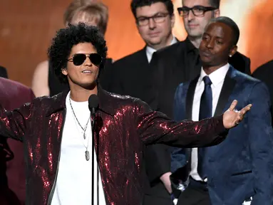 Penyanyi R&B, Bruno Mars mengangkat trofi Album of the Year pada ajang Grammy Awards 2018 di New York City, Minggu (28/1). Tak kurang dari 6 piala Grammy berhasil dibawa pulang termasuk  album of the year untuk 24K Magic. (Kevin Winter/Getty Images/AFP)