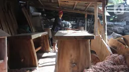 Perajin menyelesaikan pembuatan kursi dari kayu bekas di Pinang, Kota Tangerang, Banten, Minggu (28/3/2021). Furnitur berbahan dasar kayu bekas tersebut dijual dari harga Rp50.000 hingga lima juta rupiah dan dipasarkan hingga ke Sumatera dan Kalimantan. (Liputan6.com/Angga Yuniar)