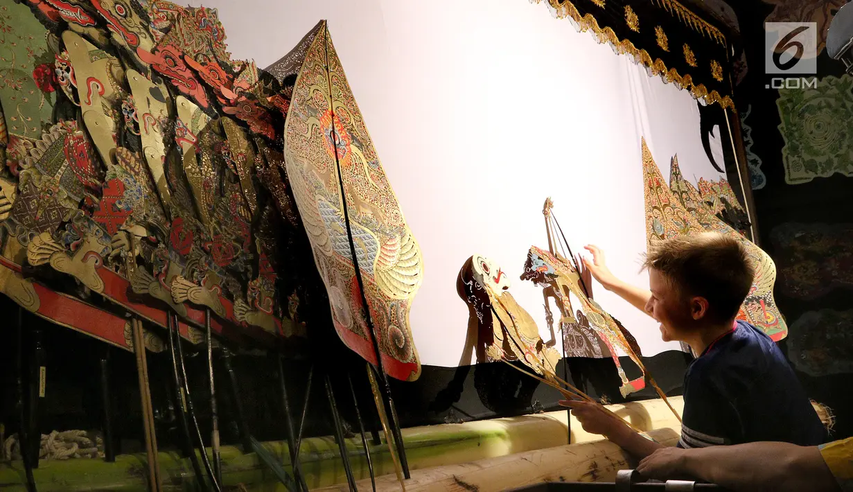 Seorang siswa sedang belajar mendalang bersama dalang Ki Purbo Asmoro pada pagelaran wayang kulit di Jakarta Intercultural School (JIS) Elementary, Jakarta, Kamis (2/11). Pagelaran ini merupakan bagian dari JIS cultural week. (Liputan6.com/Fery Pradolo)