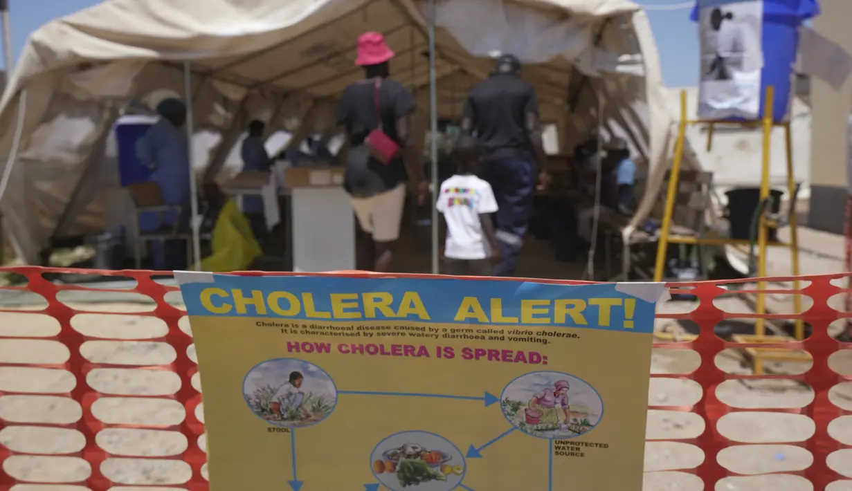 Sebuah keluarga terlihat memasuki tenda yang diperuntukkan bagi pasien kolera di sebuah klinik di Harare, Zimbabwe, Sabtu 18 November 2023. (AP Photo/Tsvangirayi Mukwazhi)