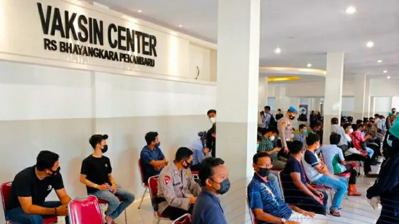 Warga mengantri di Vaksin Center Polda Riau untuk bisa menerima vaksin Covid-19.