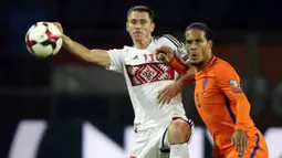 Bek Belanda, Virgil Van Dijk, berebut bola dengan striker Belarusia, Nikolai Signevich, pada laga kualifikasi Piala Dunia 2018 di Stadion Borisov Arena, Borisov, Sabtu (7/10/2017). Belarusia kalah 1-3 dari Belanda. (AP/Sergei Grits)