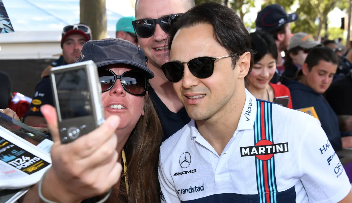 Seorang penggemar melakukan selfie dengan pembalap kawakan asal Tim Williams, Felipe Massa menjelang sesi latihan bebas pertama di Grand Prix Australia, Melbourne, Jumat (24/3). (AFP Photo/WILLIAM WEST)