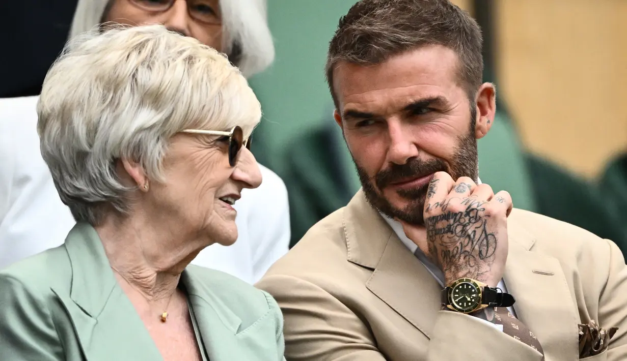 Mantan pemain sepak bola Inggris David Beckham dan ibunya Sandra Beckham duduk menyaksikan pertandingan kejuaraan tenis Wimbledon 2023 antara Daria Kasatkina dari Rusia dan Jodie Burrage dari Inggris di The All England Tennis Club di Wimbledon , London barat daya, pada 5 Juli 2023. (AFP/Sebastien Bozon)