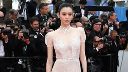 Model Ming Xi berpose di karpet merah saat tiba menghadiri pemutaran perdana film 'A Hidden Life' di festival film internasional ke-72, Cannes, Prancis selatan (19/5/2019). Model 30 tahun asal China ini tampil cantik dengan gaun putih transparan. (AP Photo/Vianney Le Caer)