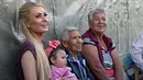 Paris Hilton berbincang dengan salah satu keluarga terkena dampak gempa bumi pada September 2017 di San Gregorio Atlapulco, Meksiko (12/11). Paris Hilton tampil mengenakan kaos, jeans dan sepatu hitam. (AFP Photo/Antonio Nava)