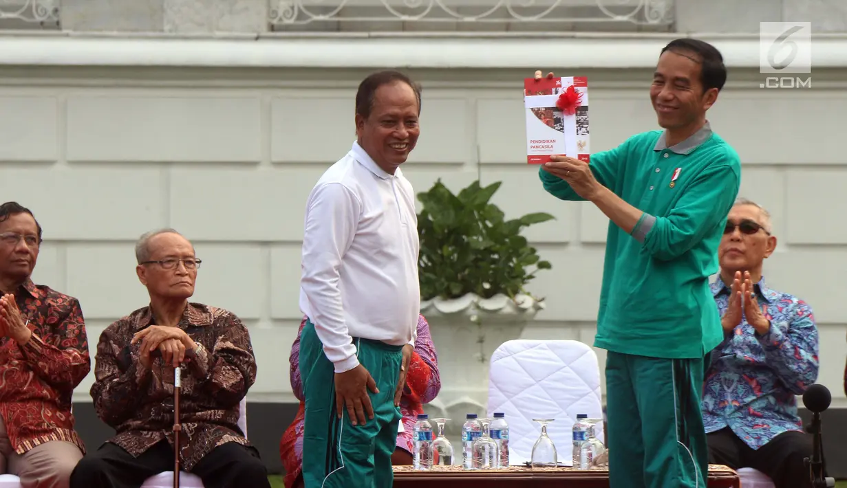 Presiden Jokowi memberi buku kepada Menristek Dikti, Muhammad Nasir saat Peluncuran Program Penguatan Pendidikan Pancasila di Istana Bogor, Jawa Barat, Sabtu (12/8). (Liputan6.com/Angga Yuniar)